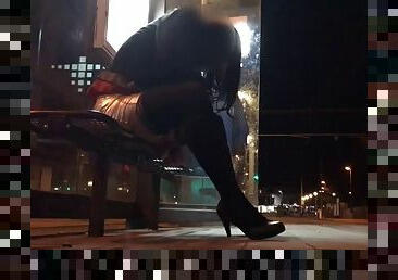 Crossdresser fixed on a bench in a tram station