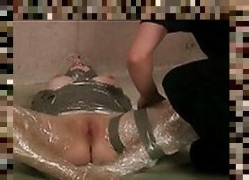 Girl is coated in plastic wrap and her body is duct taped