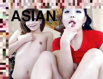 Asian lesbian couple kissing teasing on couch