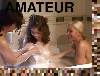 Three young girls together in the bathroom share bath