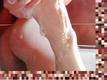 Hot blonde massaging her wet soapy feet in the bath