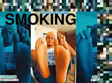 beautiful boy shows his feet while smoking