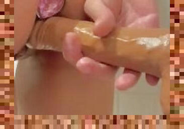 Petite girl with butt plug fucking a wall mounted dildo in the bathroom while standing - ABabyOF