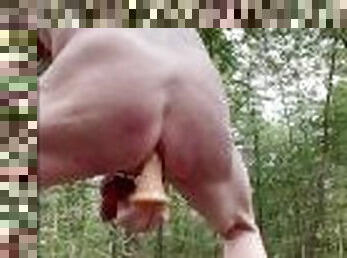 Fucking myself in a forest with a dildo.