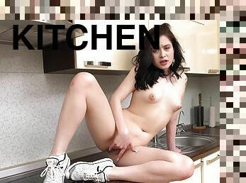 Cute babe shows off finger fucking in the kitchen