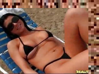 Romi Rain models a skimpy bikini on the beach