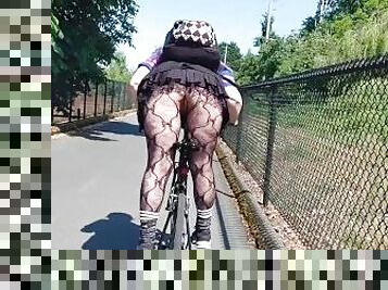 Following woman in mini skirt and fishnets biking