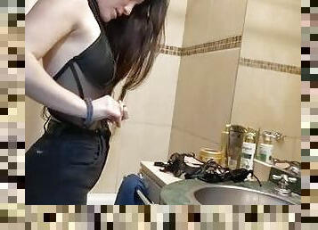 teen trying on corsets / young woman trying on clothes in a bathroom