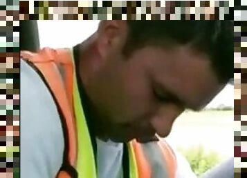 A worker in a reflective jacket sucks himself in his work car