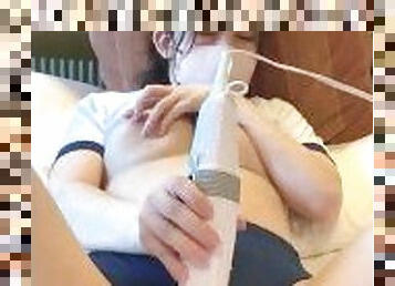 A girl in traditional Japanese gym clothes feels ecstasy with a handheld massager