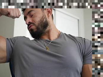 Muscular handsome guy flexes his chest in a tight shirt