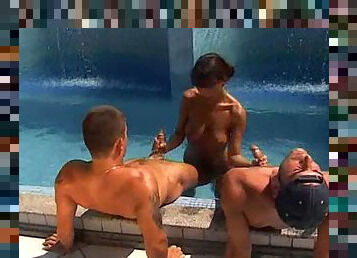 Slutty girl entertaining two cocks by the pool