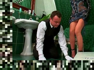 Bathroom attendant cleans up as mistress watches